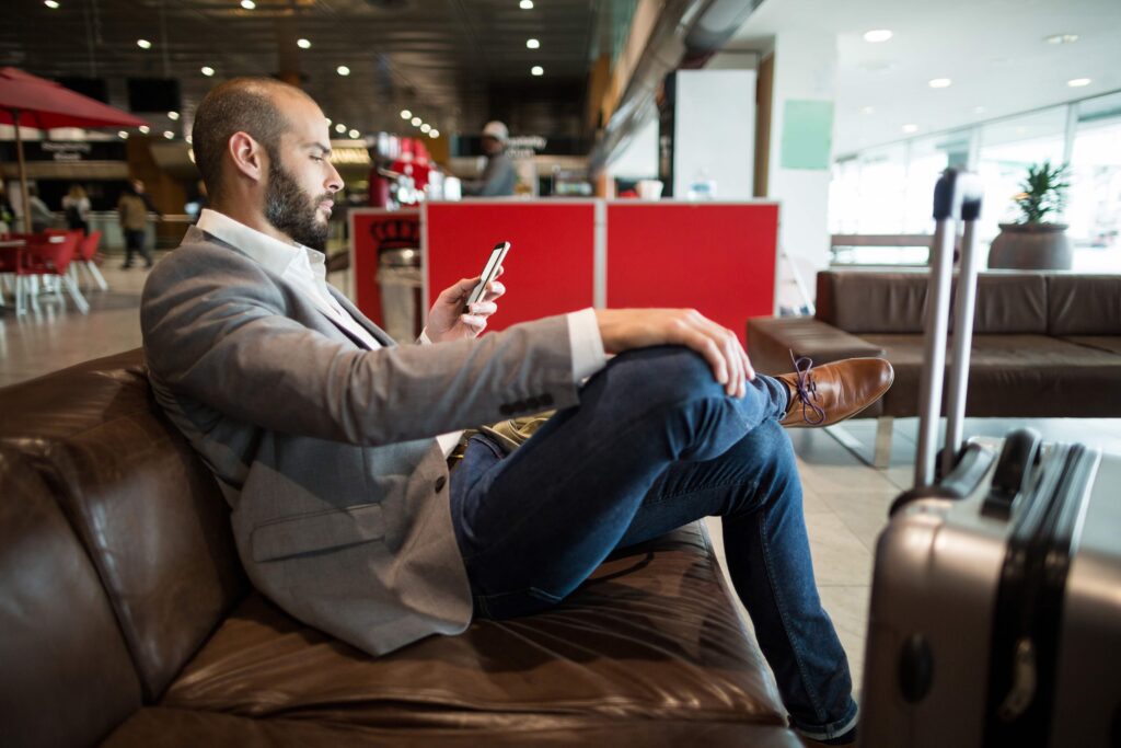 businessman-using-mobile-phone-waiting-area-flight