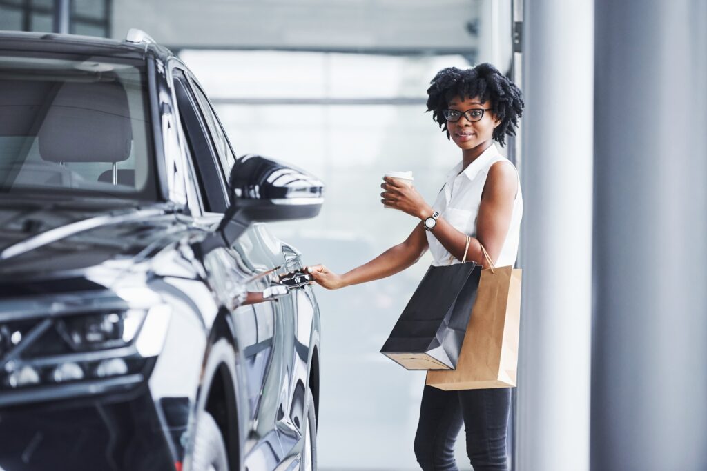 young-african-american-woman-glasses-stands-car-salon